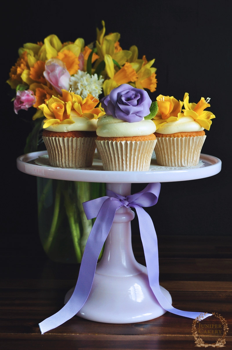 Cupcakes adorned with daffodils and roses by Juniper Cakery