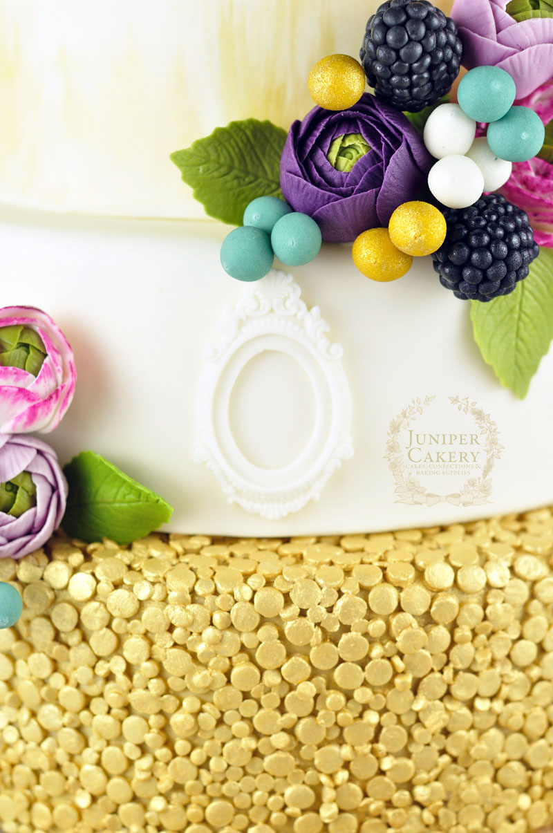 Beautiful gold and purple ranunculus wedding cake by Juniper Cakery