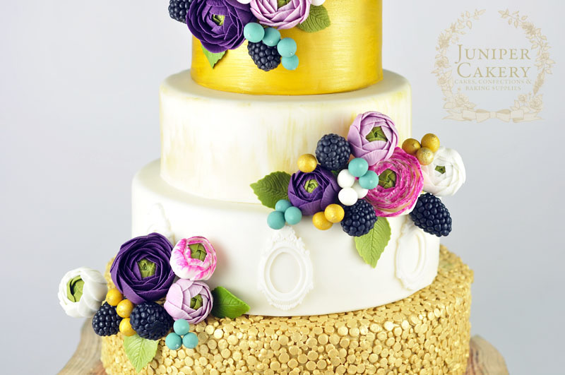 Stunning gold, pink and purple ranunculus wedding cake by Juniper Cakery