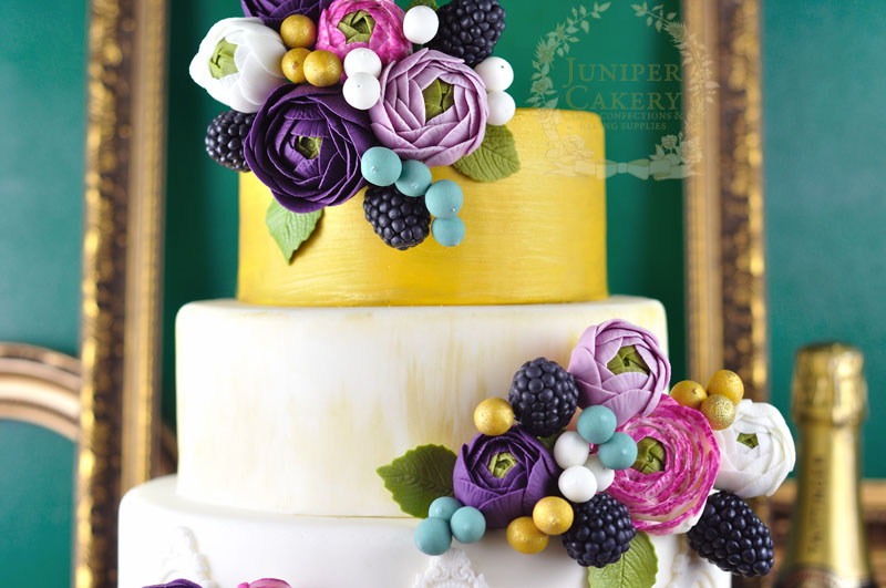 Gorgeous bright ranunculus flower wedding cake by Juniper Cakery