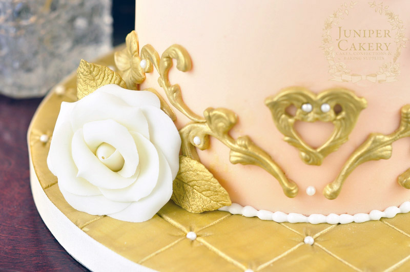 Gold cake board with rose by Juniper Cakery