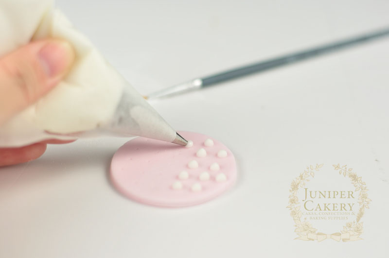 Piping dots with royal icing by Juniper Cakery