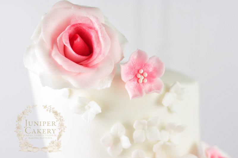 Pink rose and cherry blossom with hydrangeas on a topsy turvy cake by Juniper Cakery