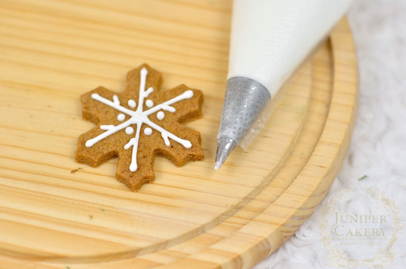 Piping snowflake cookies by Juniper Cakery