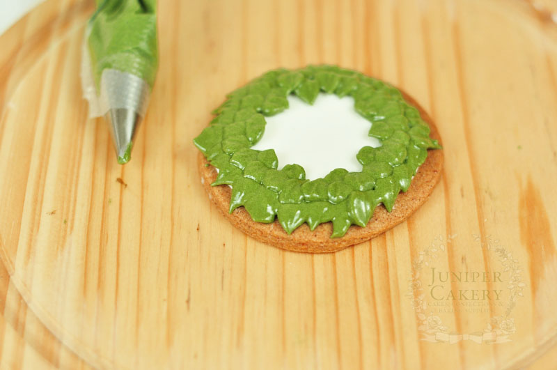 Piping Christmas wreath cookies by Juniper Cakery