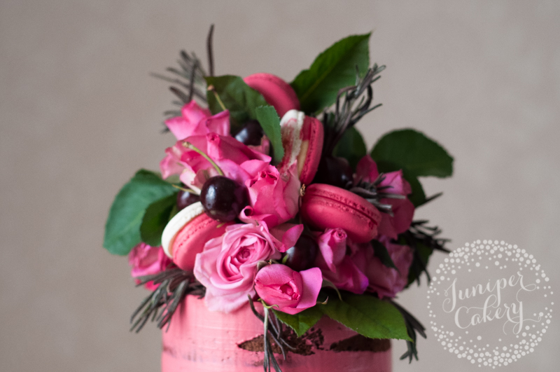 Naked wedding cake with pink cherry macarons by Juniper Cakery