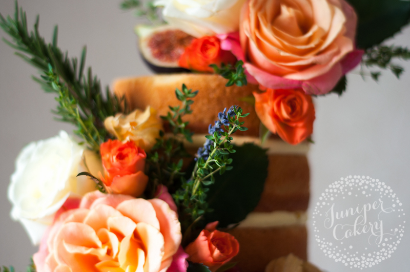 Orange and coral themed naked wedding cake by Juniper Cakery