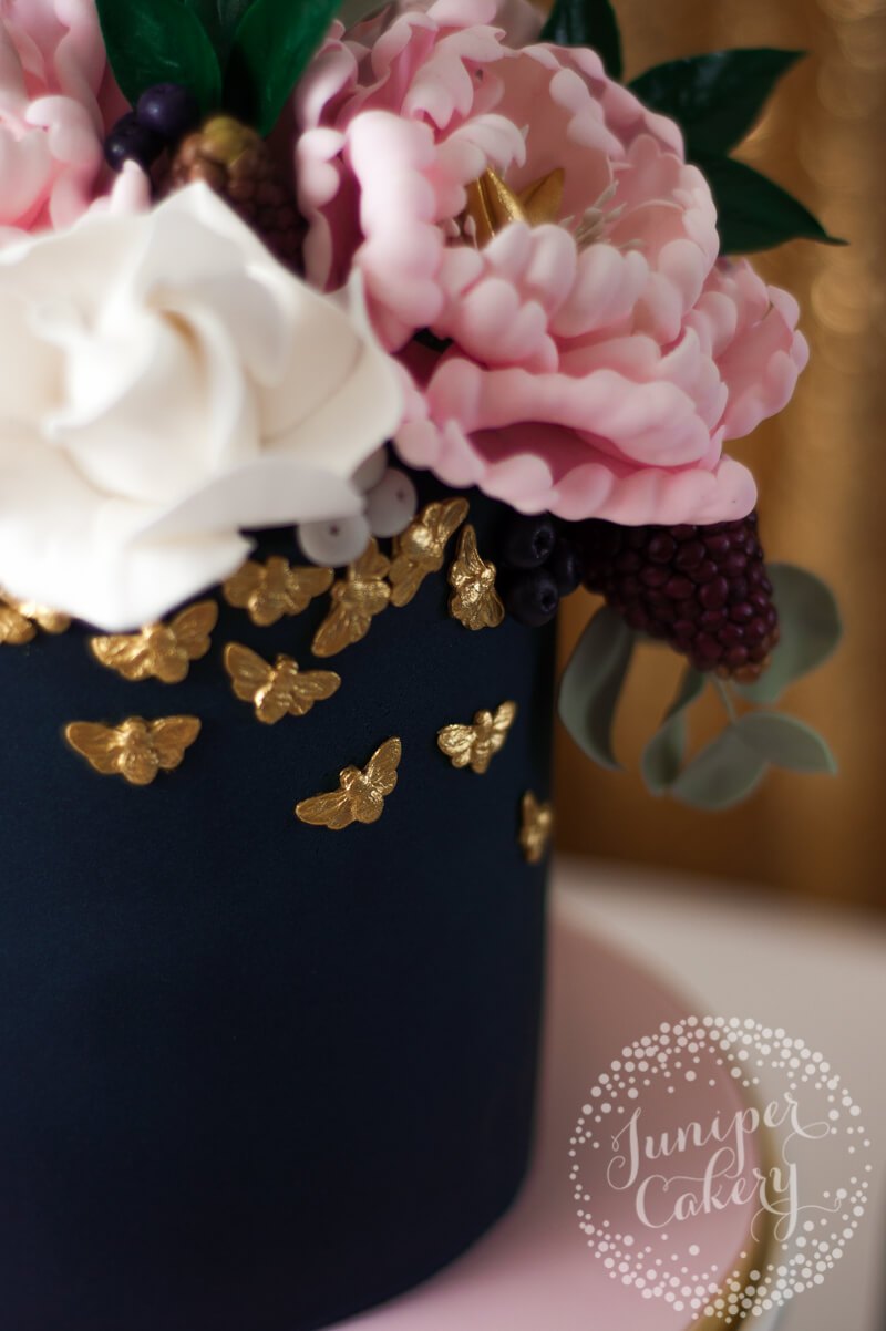 Navy and blush floral peony cake with gold bees by Juniper Cakery