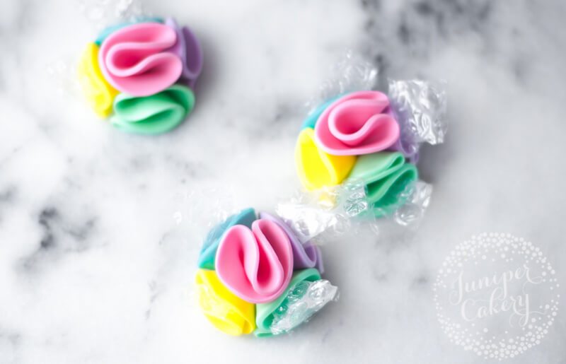 Pretty rainbow pom pom cupcakes by Juniper Cakery