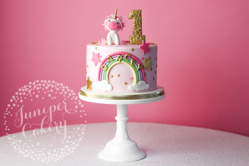 Cute pink unicorn birthday cake with rainbow by Juniper Cakery