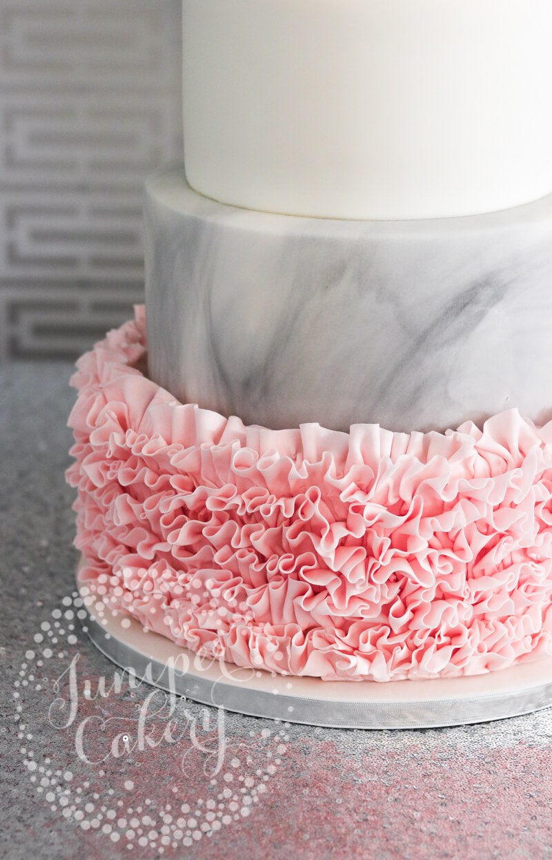 Pink fondant ruffle cake with grey marbled fondant by Juniper Cakery